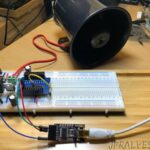 The image shows a circuit board with wiring, ICs, and a siren. Source: https://jpralves.net/post/2020/01/02/do-it-yourself-siren-alarm-based-on-esp32-wemos-d1-r1.html